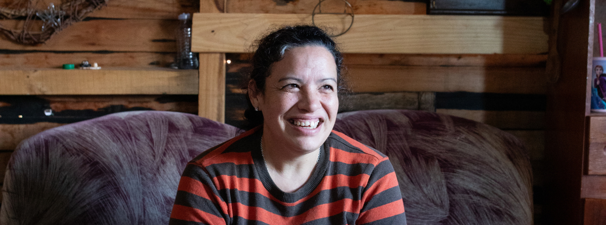 Mujer en una vivienda vulnerable sonriendo